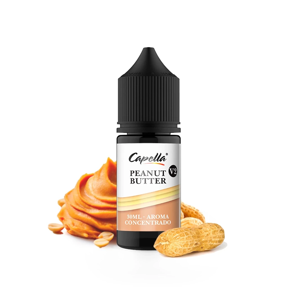 Frasco de aroma Peanut Butter V2 de Capella de 30 ml, con tapón negro, junto a crema de cacahuete y cacahuetes sobre fondo blanco.