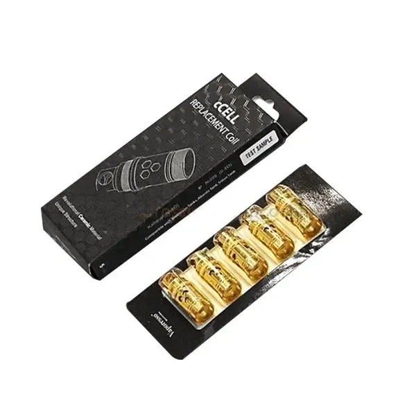 Resistencias CCELL doradas en un blíster junto a una caja negra con el texto CCELL Replacement Coil, sobre fondo blanco.