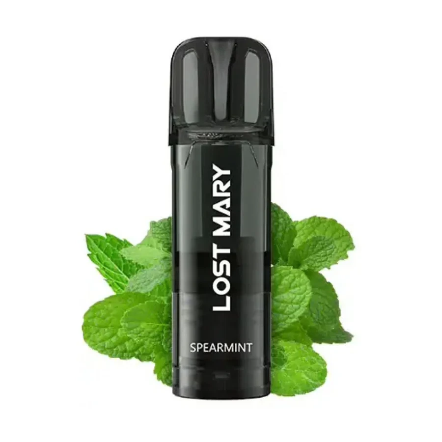 Cartucho Lost Mary Spearmint oscuro, con boquilla translúcida y letras blancas, colocado delante de hojas verdes de menta sobre fondo blanco.