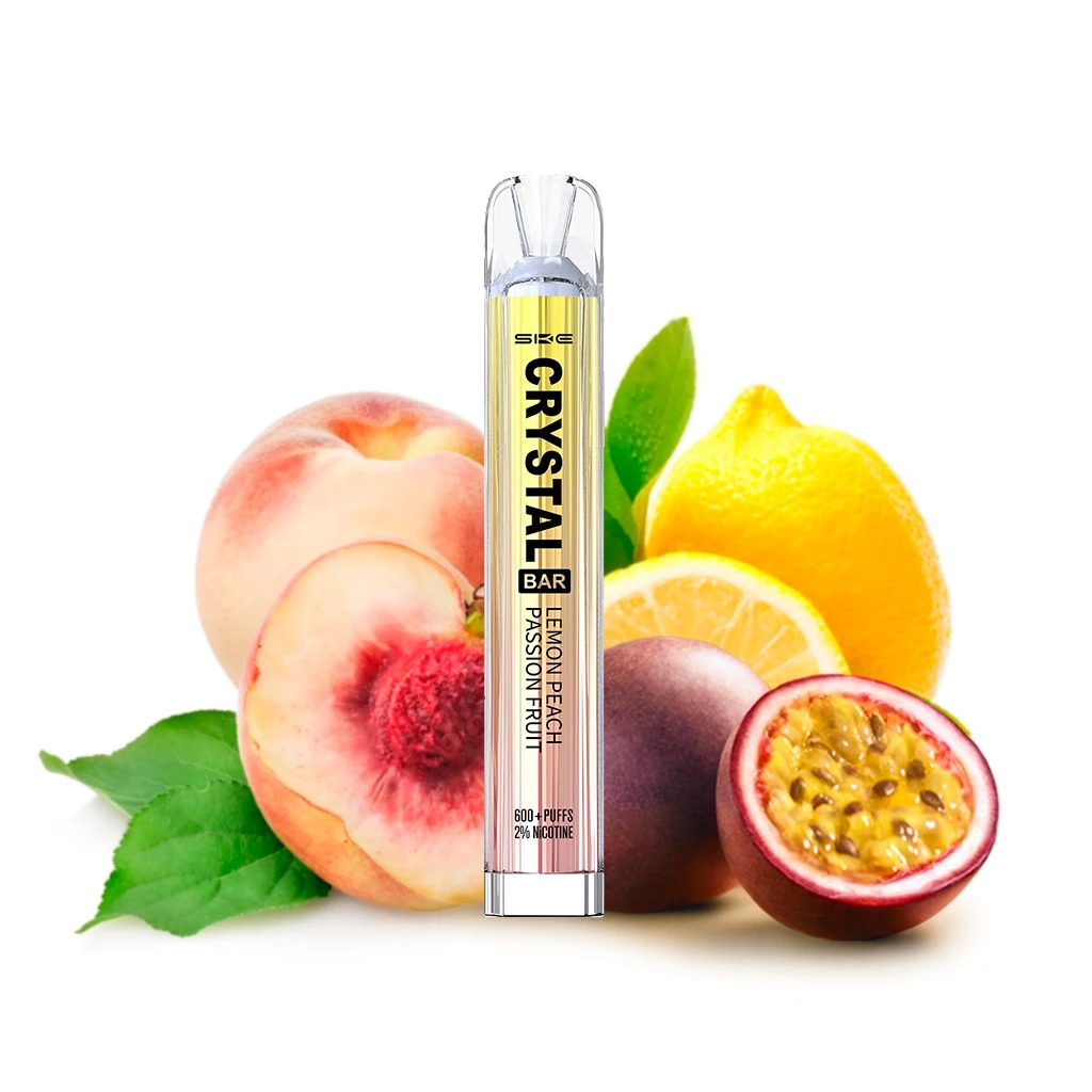 Vapeador SKE Crystal Bar Lemon Peach Passion Fruit en posición vertical, rodeado de melocotón, limón y maracuyá sobre fondo blanco.