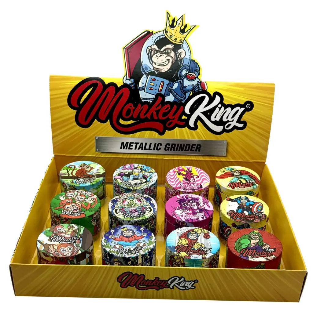 Expositor amarillo de grinders Monkey King con distintos diseños multicolores de monos y un cartel con un mono astronauta coronado.