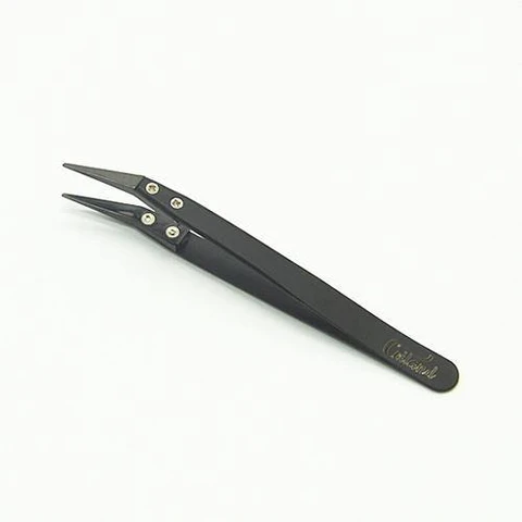 Pinzas Coiland Ceramic Tweezer negras, con puntas finas y tornillos visibles, colocadas en diagonal sobre fondo blanco.