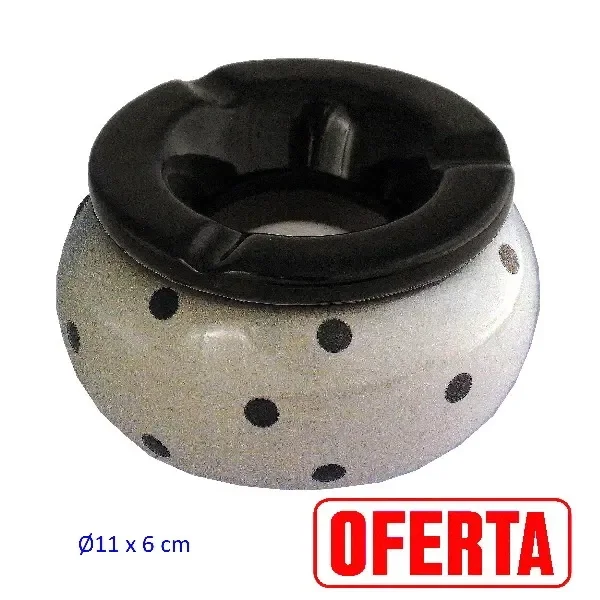 Cenicero de mesa redondo, de cuerpo claro con lunares negros y borde negro ancho con varias muescas, sobre fondo blanco.