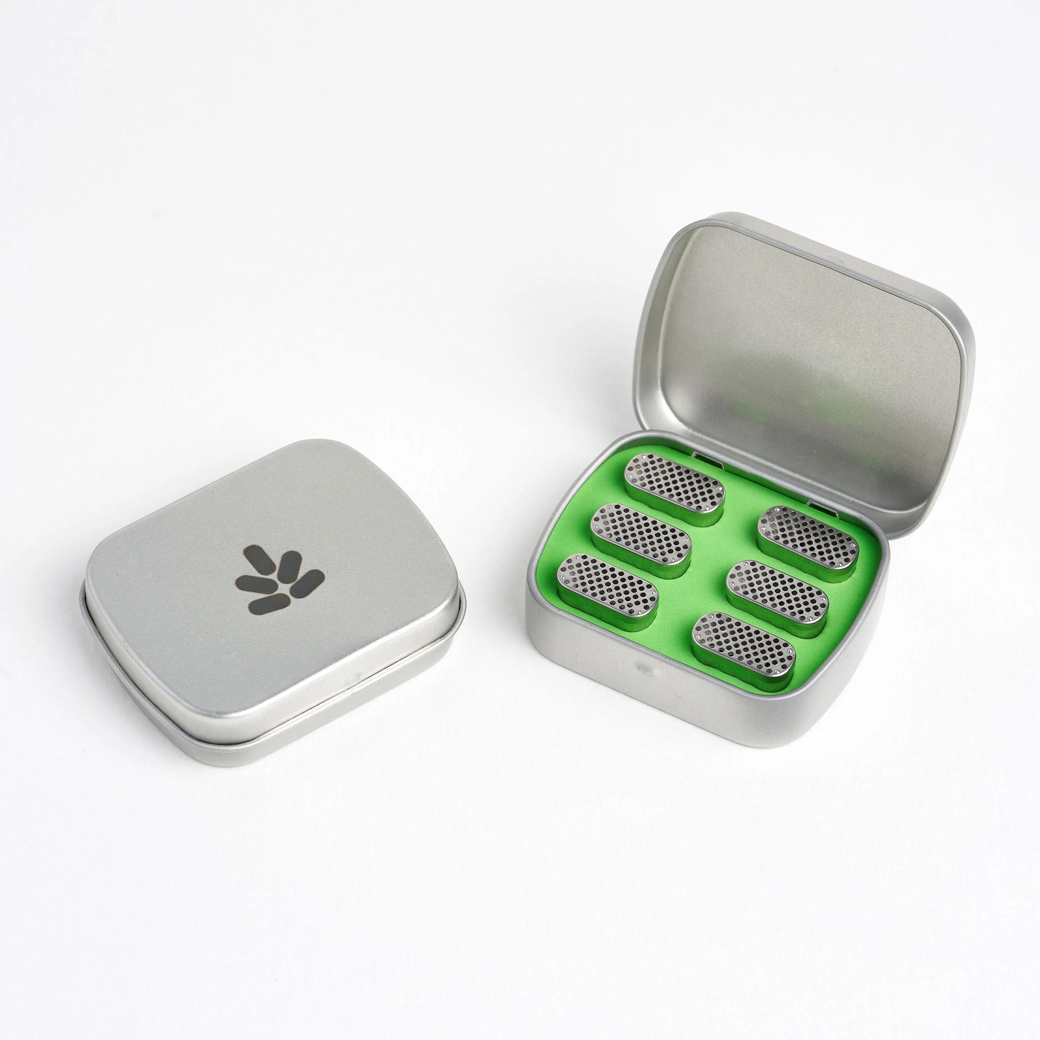 Bud Case Bundle para Pax 2 y Pax 3, con estuche plateado abierto, interior verde y cápsulas perforadas, junto a otro estuche cerrado.