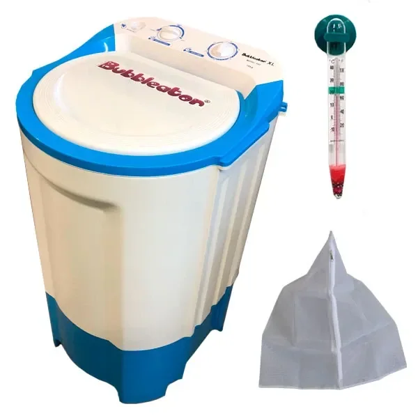 Lavadora Bubbleator XL blanca y azul, con tapa y mandos superiores, junto a un termómetro y una bolsa de malla blanca. Lavadora Bubbleator XL blanca y azul, con tapa y mandos superiores, junto a un termómetro y una bolsa de malla blanca.