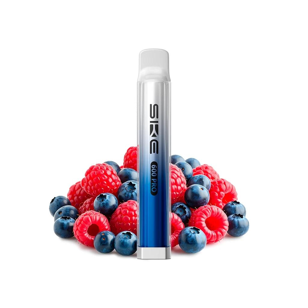 Pod SKE Crystal 600 Pro Blueberry Raspberry con cuerpo azul y transparente, de pie entre frambuesas y arándanos sobre fondo blanco. Pod SKE Crystal 600 Pro Blueberry Raspberry con cuerpo azul y transparente, de pie entre frambuesas y arándanos sobre fondo blanco.