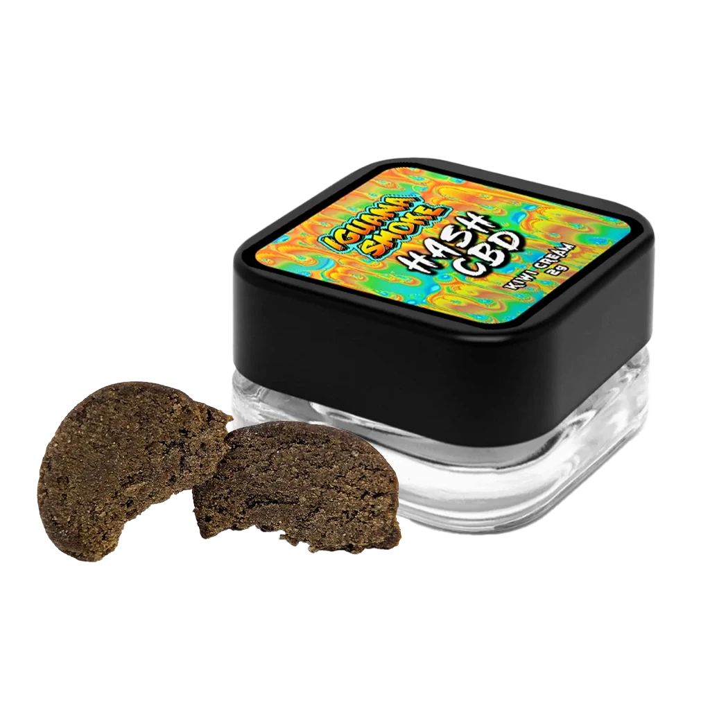 Hash Kiwi Creams CBD de Iguana Smoke en fragmentos marrones junto a un tarro transparente con tapa negra y etiqueta multicolor, sobre fondo negro.