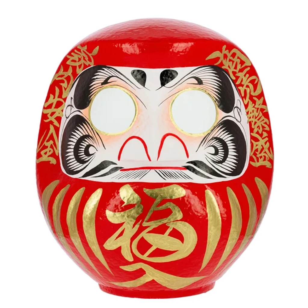 Daruma rojo de Tierra Zen, de cuerpo redondeado, con caracteres dorados, rostro blanco y negro y ojos blancos sin pupilas. Daruma rojo de Tierra Zen, de cuerpo redondeado, con caracteres dorados, rostro blanco y negro y ojos blancos sin pupilas.