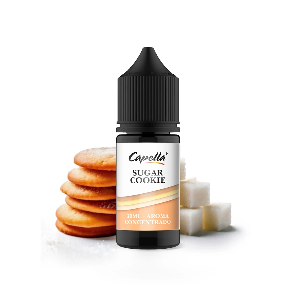Frasco Capella Sugar Cookie de 30 ml con tapón negro, junto a una pila de galletas doradas y terrones de azúcar sobre fondo blanco.