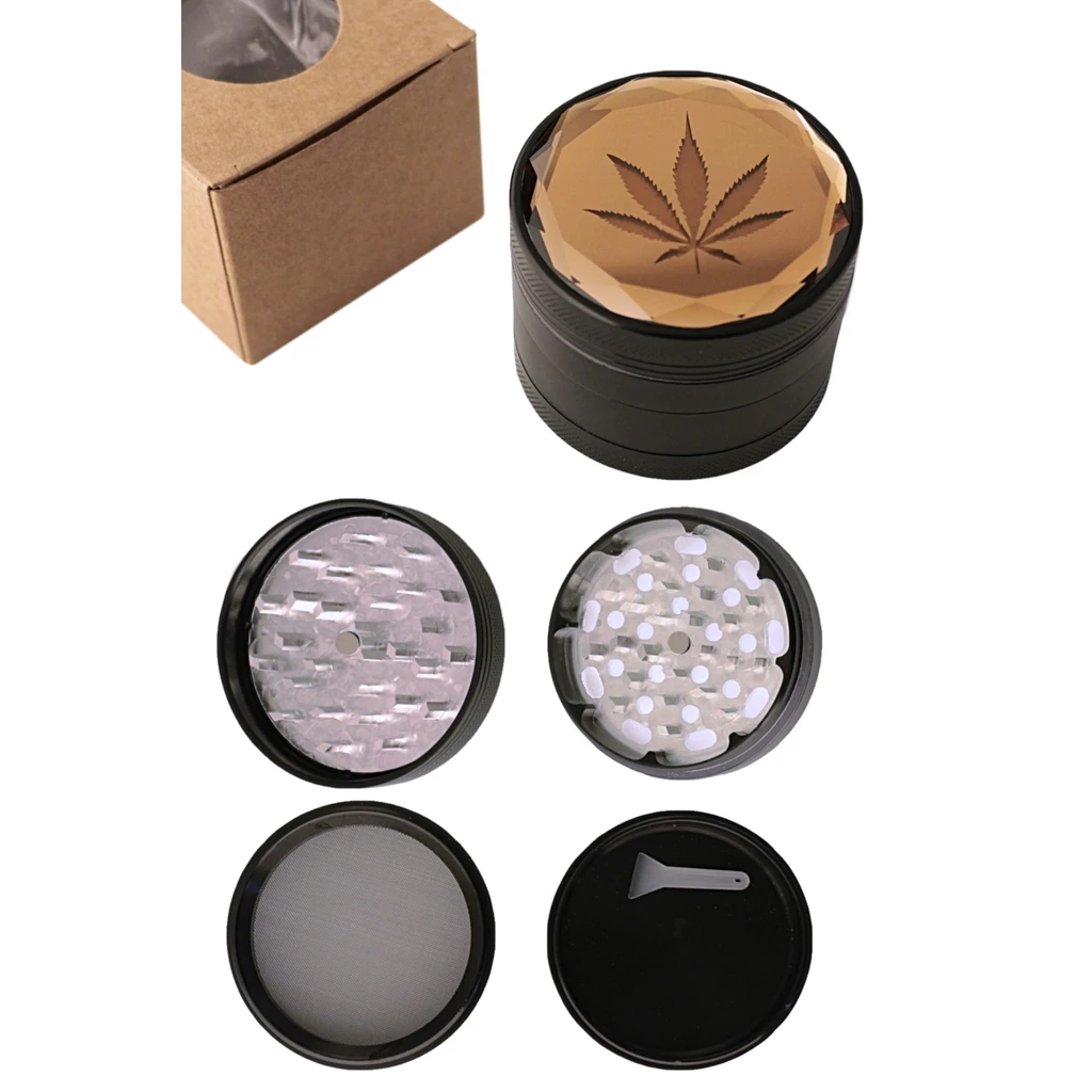 Grinder negro con tapa facetada ámbar y hoja de cannabis, mostrado montado y con sus piezas separadas, tamiz y pequeña espátula.