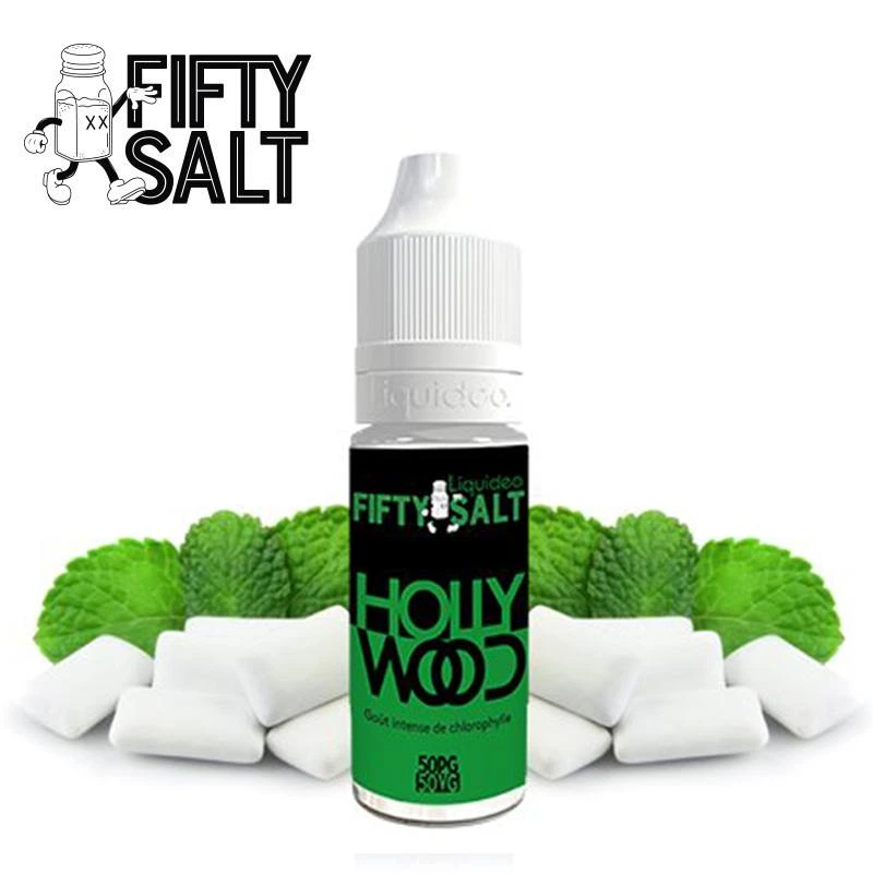Frasco de e-líquido HOLLYWOOD Fifty Salt con tapón blanco y etiqueta negra y verde, delante de hojas verdes y piezas blancas de chicle.