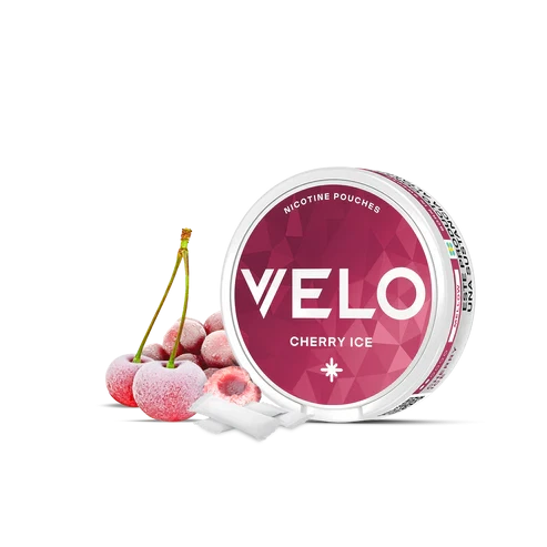Envase redondo de VELO Cherry Ice con etiqueta rosa, junto a cerezas con aspecto escarchado y bolsas blancas, sobre fondo negro. Envase redondo de VELO Cherry Ice con etiqueta rosa, junto a cerezas con aspecto escarchado y bolsas blancas, sobre fondo negro.