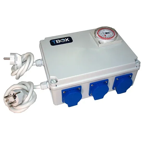 Temporizador TBOX en caja gris con reloj analógico superior, tomas con tapas azules en el frontal y cables blancos con enchufes.