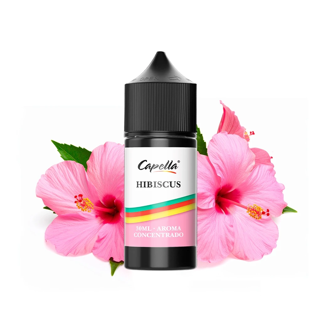 Frasco negro de aroma Capella Hibiscus de 30 ml, con etiqueta blanca y rosa, delante de flores de hibisco rosas sobre fondo blanco.