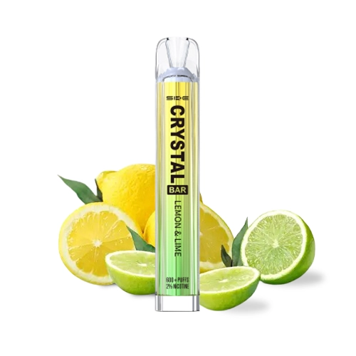 Vaper SKE Crystal Bar Lemon & Lime de cuerpo amarillo y verde con boquilla transparente, delante de limones y limas cortados.
