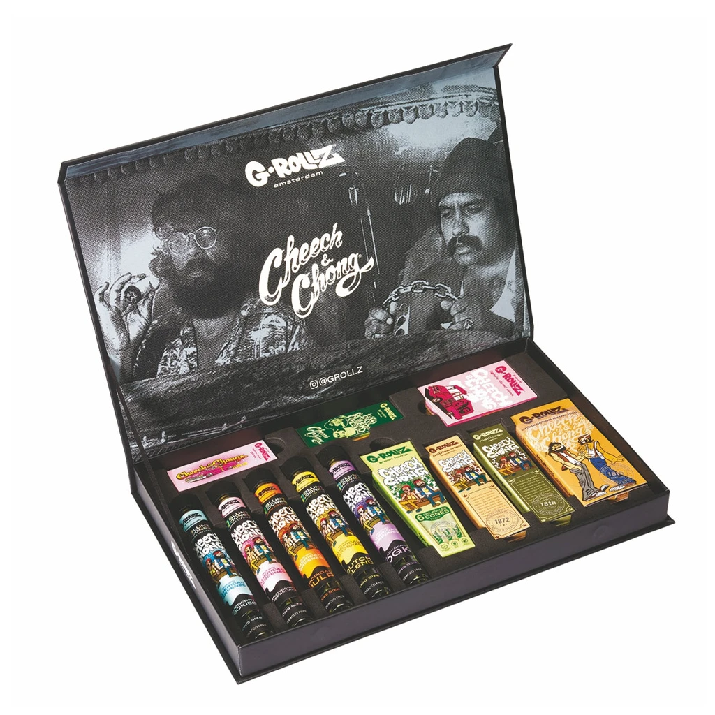 Caja G-Rollz Cheech & Chong abierta, con retratos en la tapa y una selección de tubos y paquetes de distintos formatos y colores en el interior.