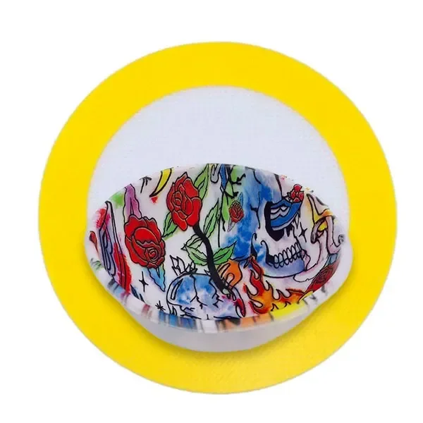 Cuenco de silicona Skulls con estampado de calaveras, rosas y llamas, sobre un tapete circular con borde amarillo.