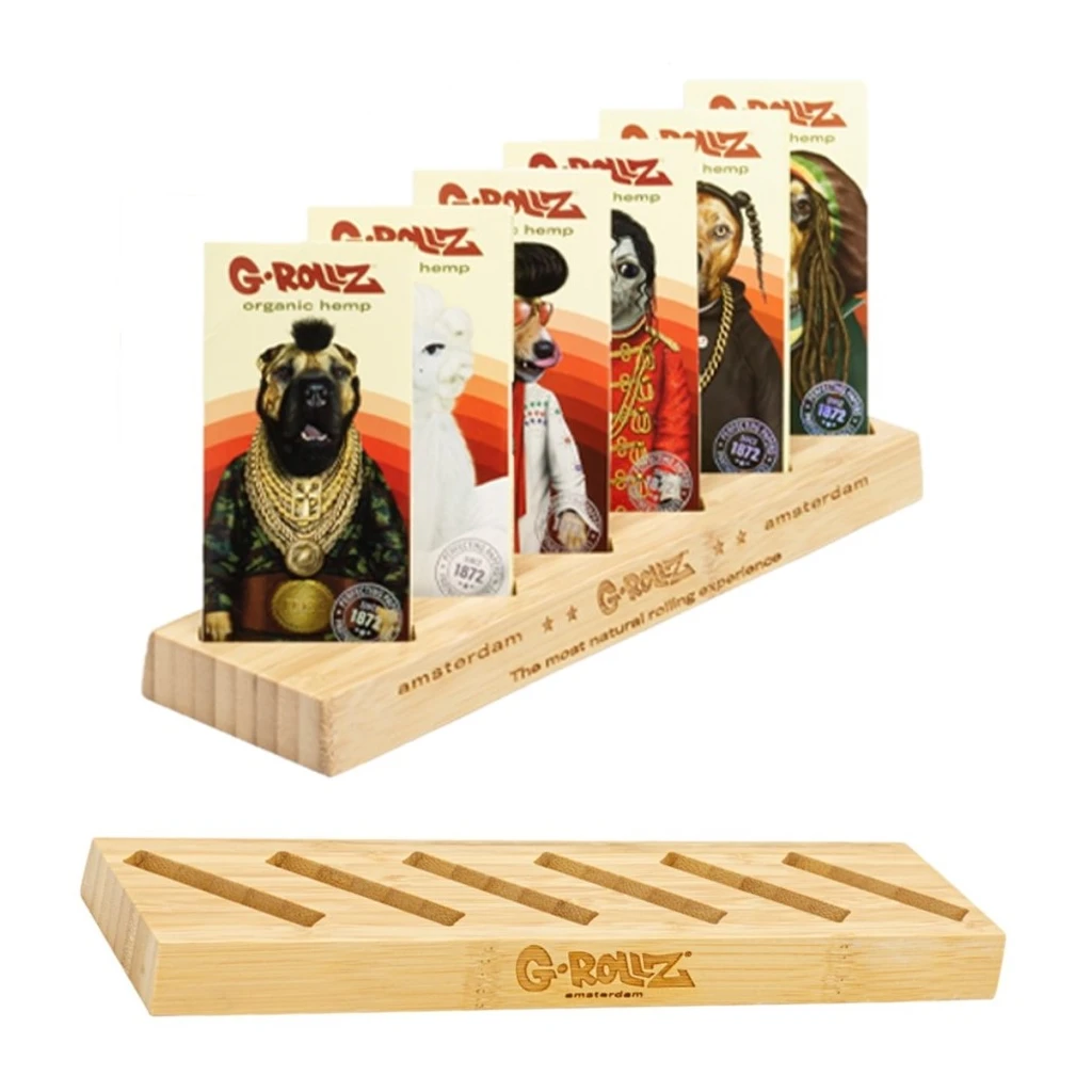 Expositor G-Rollz con ranuras, mostrado vacío y con libritos de papel de fumar decorados con personajes de animales.