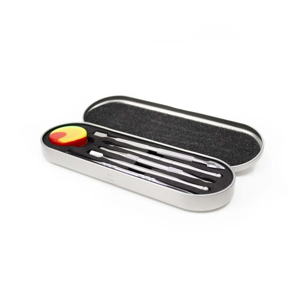 Set de dabbers de acero inoxidable con distintas puntas en un estuche metálico abierto y un pequeño recipiente rojo y amarillo.