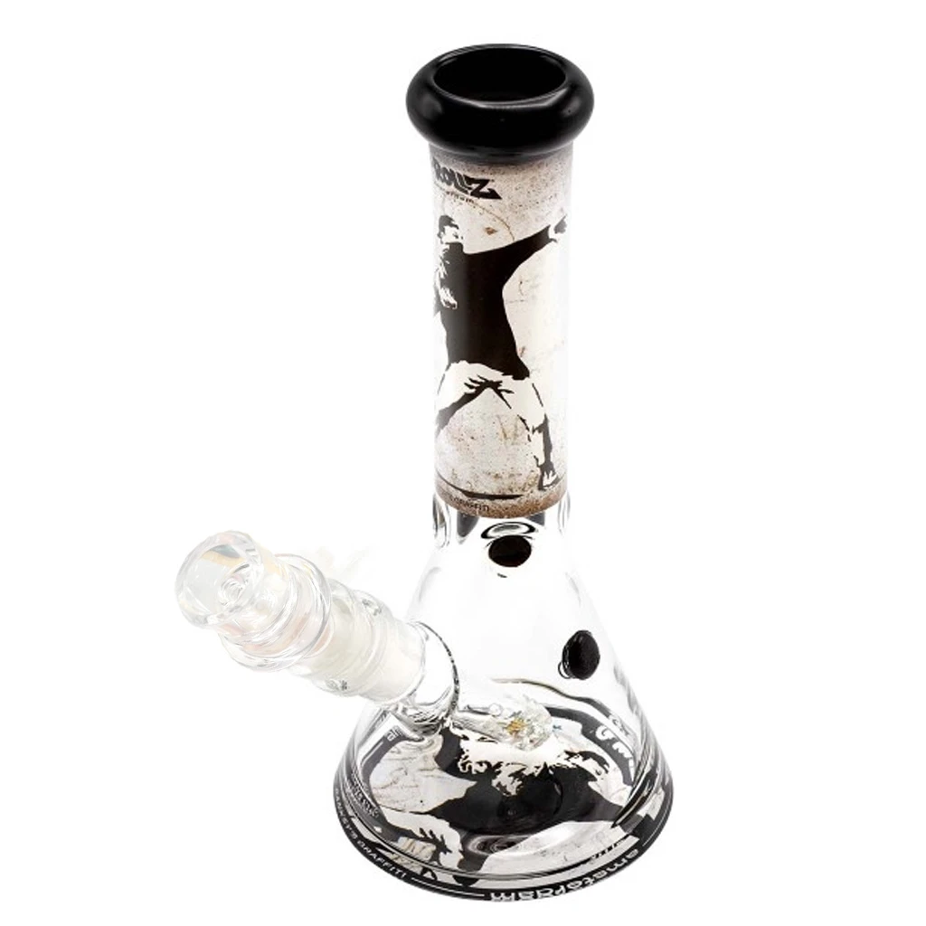 Bong transparente de base ancha y cuello largo, con borde negro, cazoleta lateral inclinada y decoración negra de una figura lanzando flores.