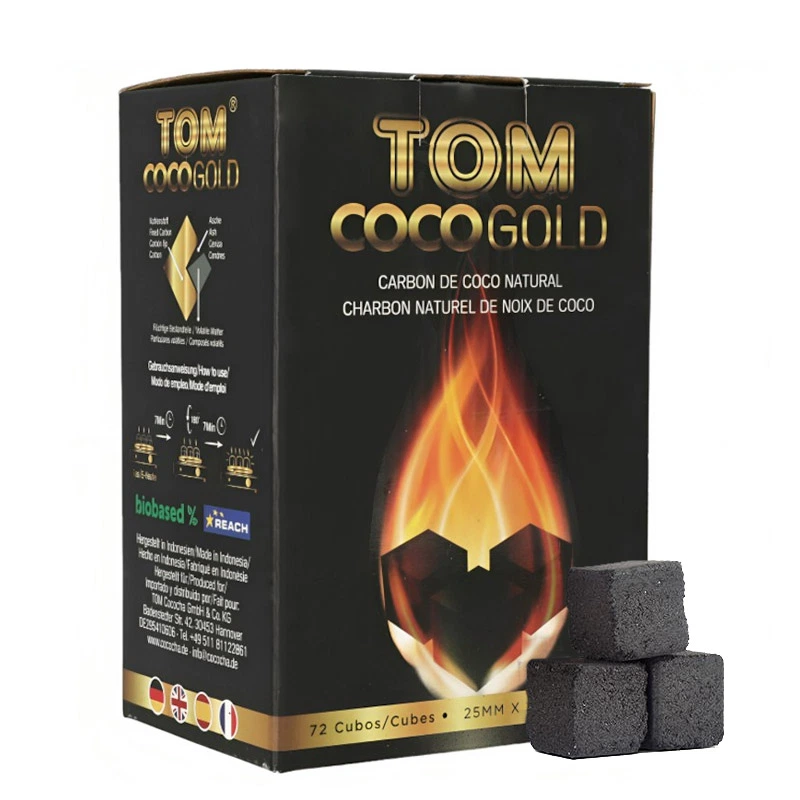 Caja negra y dorada TOM Coco Gold con una llama impresa y varios cubos de carbón oscuro apilados delante. Caja negra y dorada TOM Coco Gold con una llama impresa y varios cubos de carbón oscuro apilados delante.