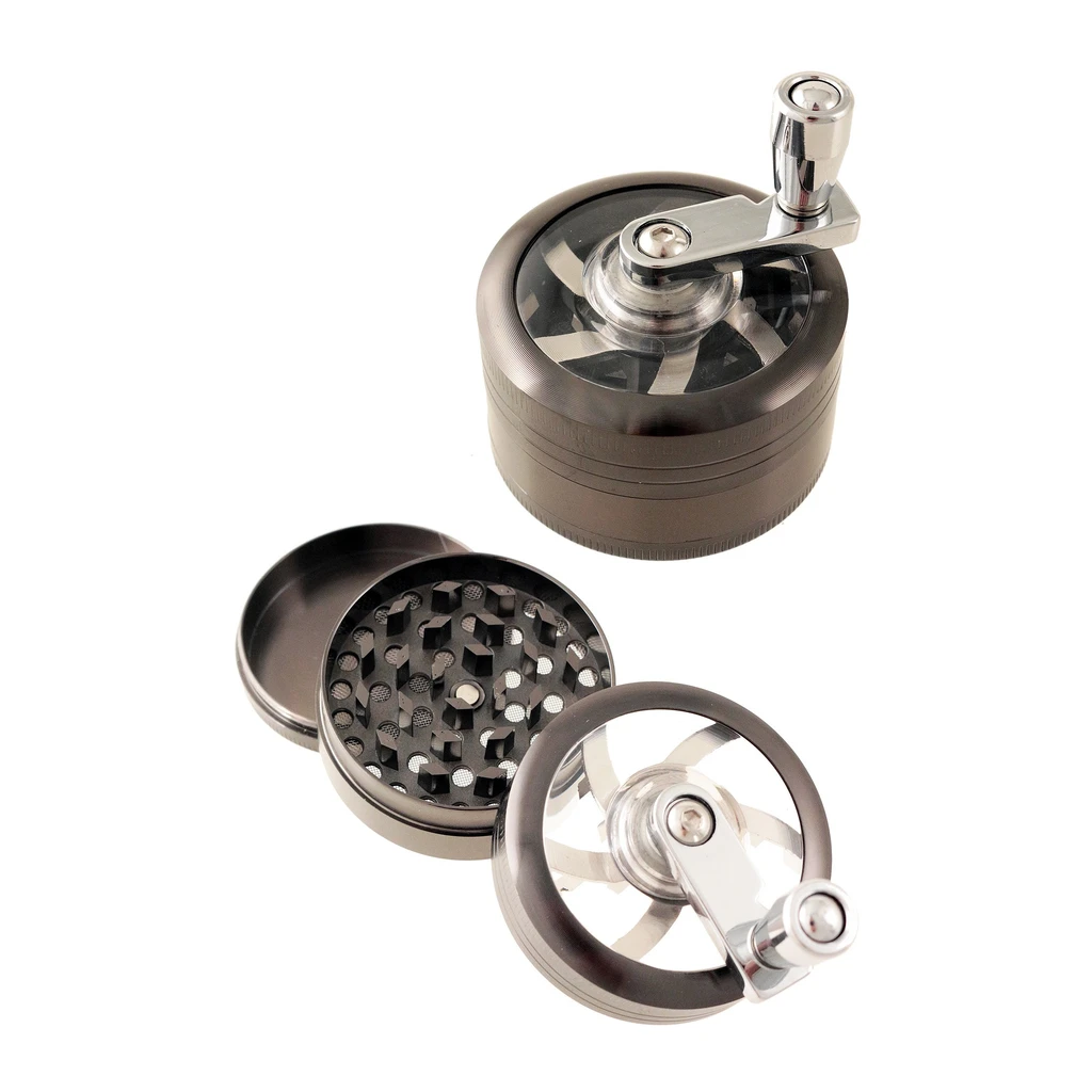 Grinder gris oscuro con manivela y tapa transparente, mostrado cerrado y desmontado para ver los dientes y el recipiente.
