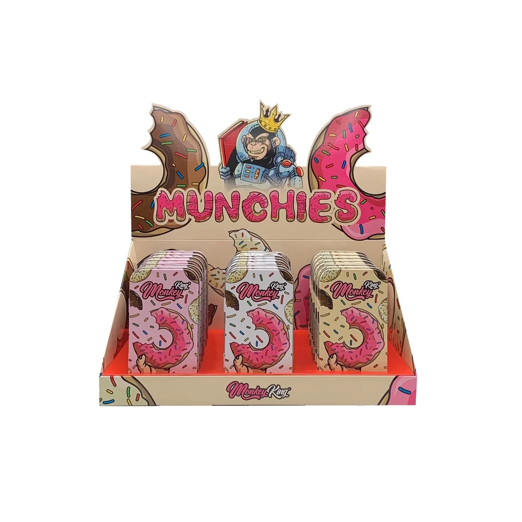 Expositor Munchies de Monkey King con varias cajas rectangulares decoradas con donuts rosas y un mono coronado en el cartel.