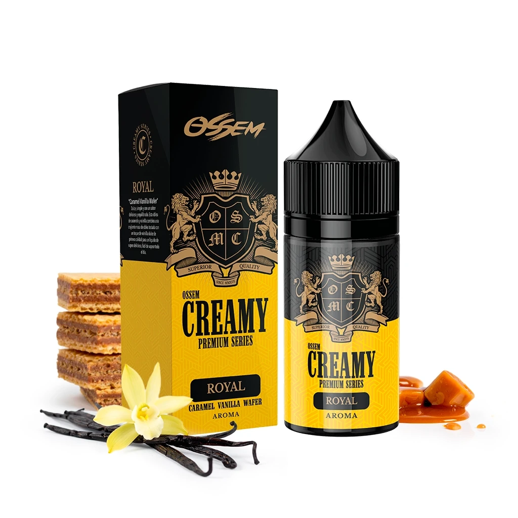 Frasco y caja negros y amarillos de Ossem Creamy Royal, rodeados de barquillos, vainas y flor de vainilla y caramelos sobre fondo blanco.