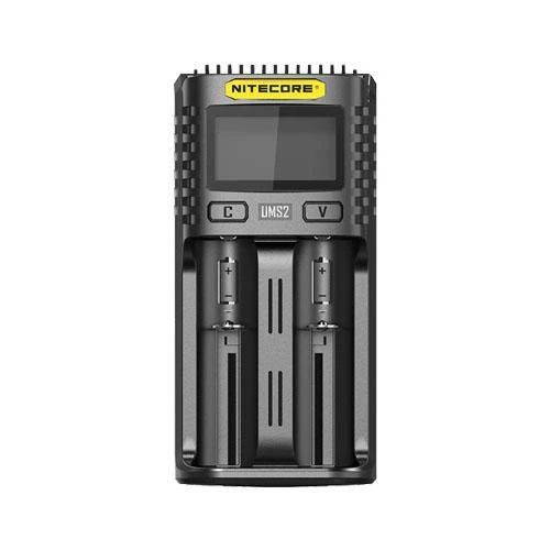 Cargador negro Nitecore UMS2 visto de frente, con pantalla superior, dos botones y dos alojamientos vacíos para baterías. Cargador negro Nitecore UMS2 visto de frente, con pantalla superior, dos botones y dos alojamientos vacíos para baterías.