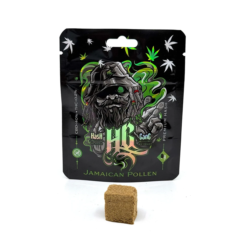 Envase negro de Hash Gang Jamaican Pollen con un personaje barbudo y motivos verdes, junto a un bloque marrón de textura granulada.