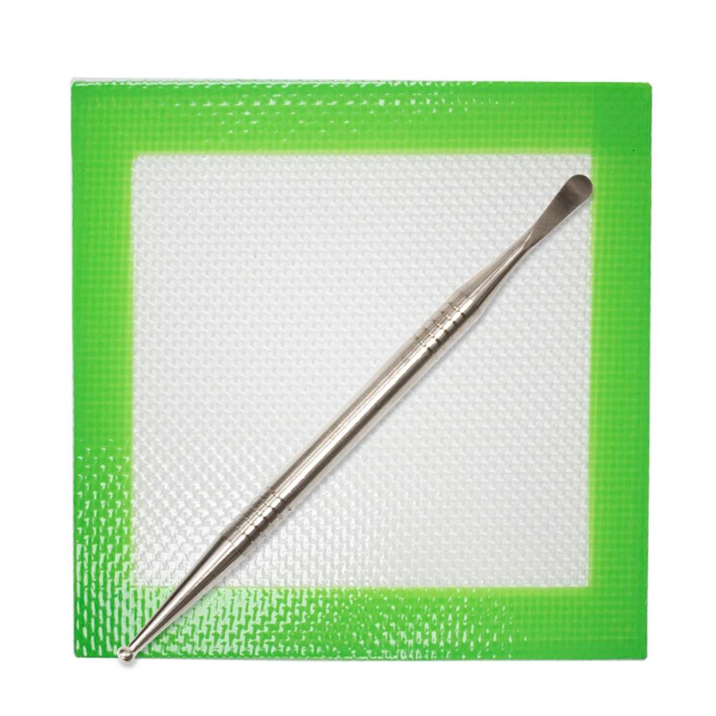 Dabber de doble punta colocado en diagonal sobre un tapete cuadrado con centro blanco y borde verde.