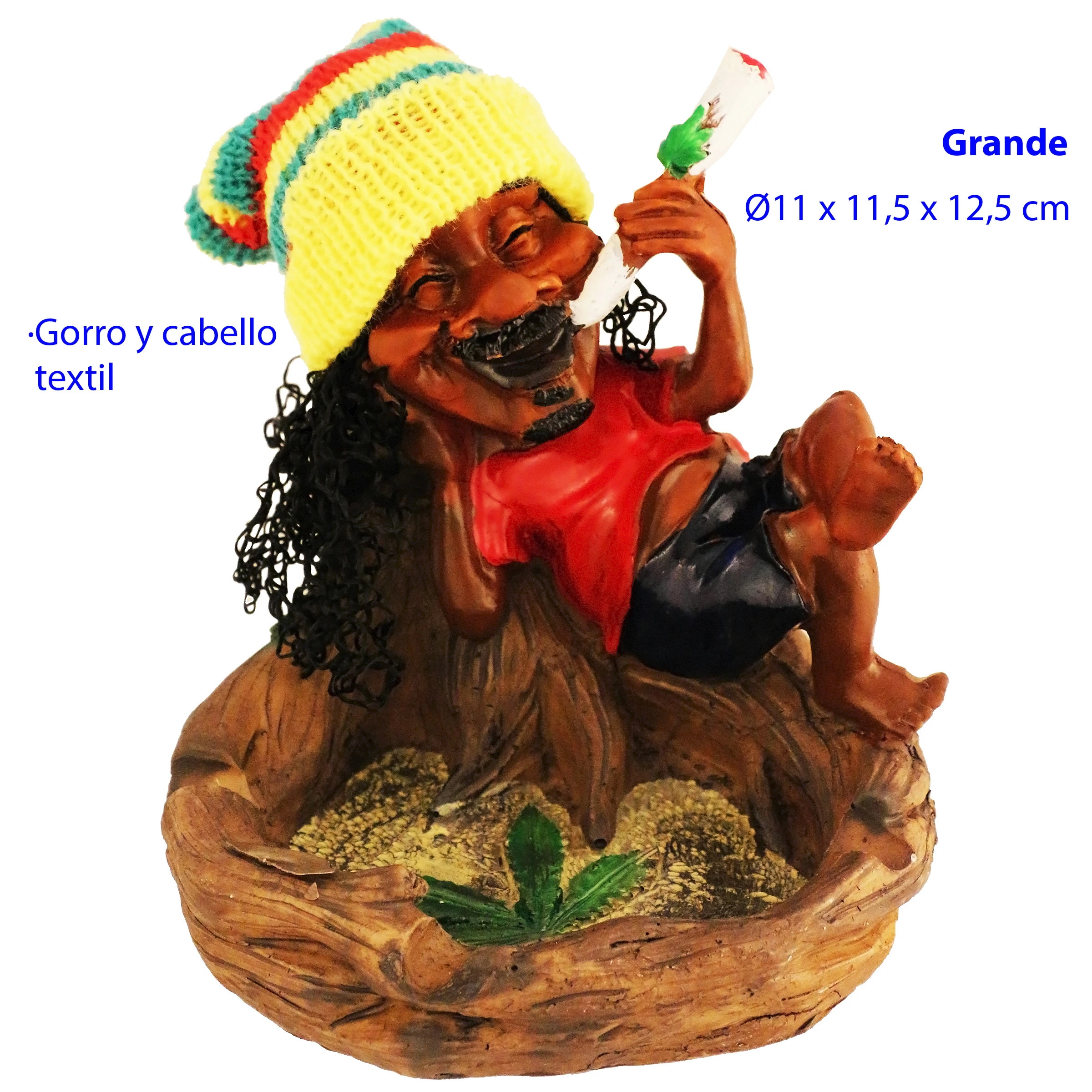 Cenicero con figura rasta sentada en un tronco, gorro multicolor, cabello rizado y un cigarrillo en la mano; hoja verde en la base.