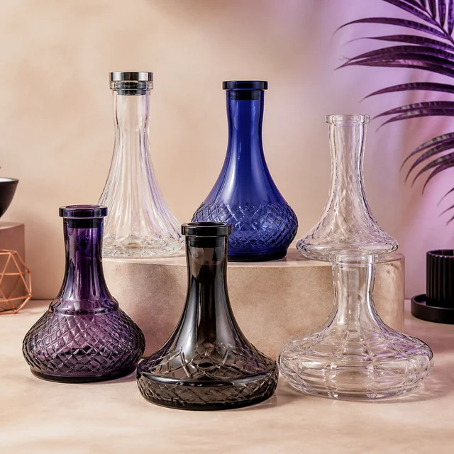 Seis bases de cachimba de distintas formas, transparentes, moradas, azul y ahumada, con relieves decorativos y cuellos estrechos.