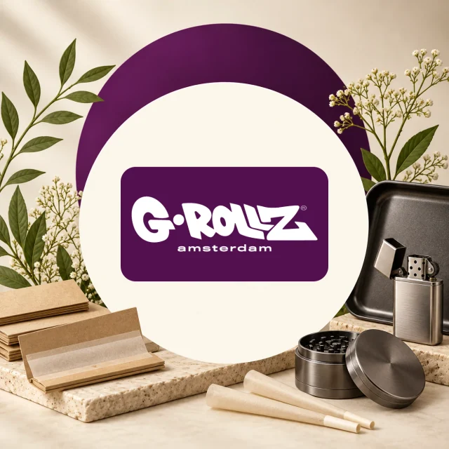 Logotipo G-Rollz Amsterdam rodeado de papeles y conos para liar, un grinder abierto, una bandeja negra y un encendedor metálico. Logotipo G-Rollz Amsterdam rodeado de papeles y conos para liar, un grinder abierto, una bandeja negra y un encendedor metálico.