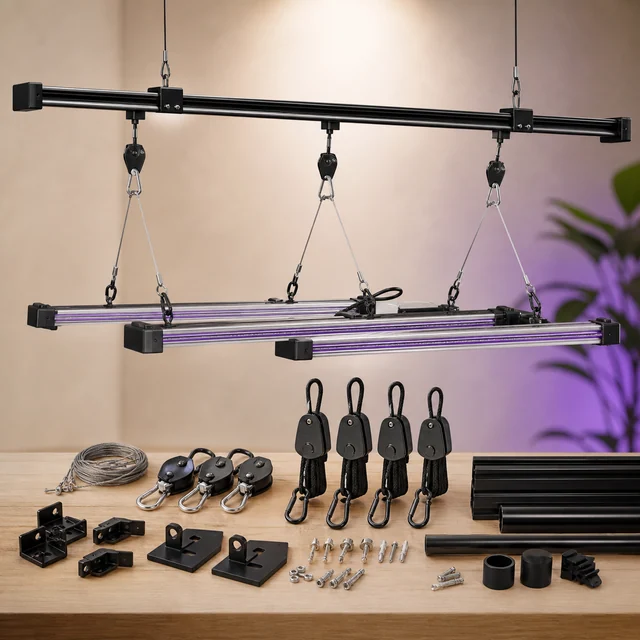 Sistema de raíles con barras de iluminación suspendidas mediante poleas y cables, junto a perfiles, soportes y tornillería sobre una mesa.