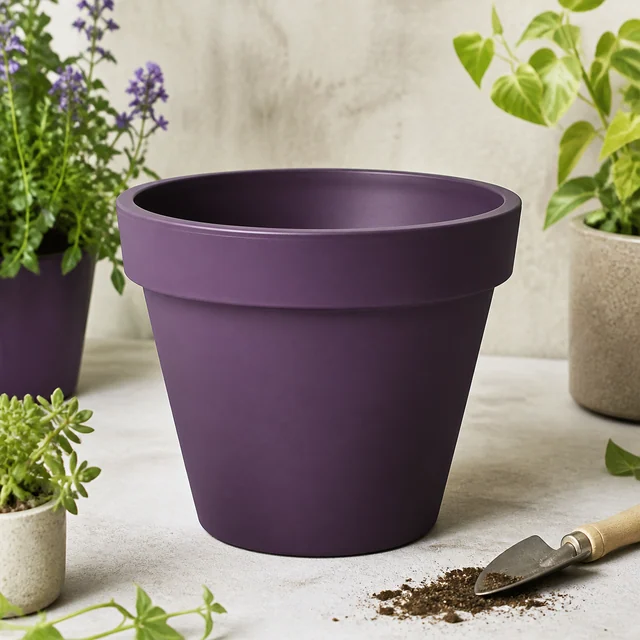 Maceta morada vacía de forma redonda y borde ancho, sobre una mesa clara junto a plantas y una pala con tierra. Maceta morada vacía de forma redonda y borde ancho, sobre una mesa clara junto a plantas y una pala con tierra.