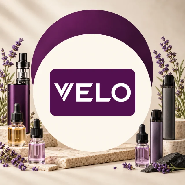 Logotipo VELO en el centro, flanqueado por dispositivos de vapeo y frascos con cuentagotas entre flores de lavanda. Logotipo VELO en el centro, flanqueado por dispositivos de vapeo y frascos con cuentagotas entre flores de lavanda.
