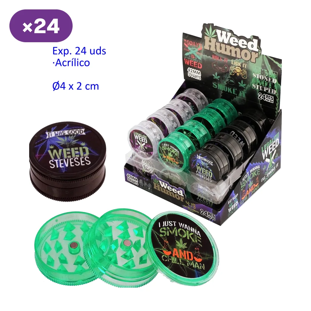 Expositor Weed Humor con grinders transparentes, verdes y negros; delante aparecen un modelo cerrado y otro verde abierto con dientes visibles.
