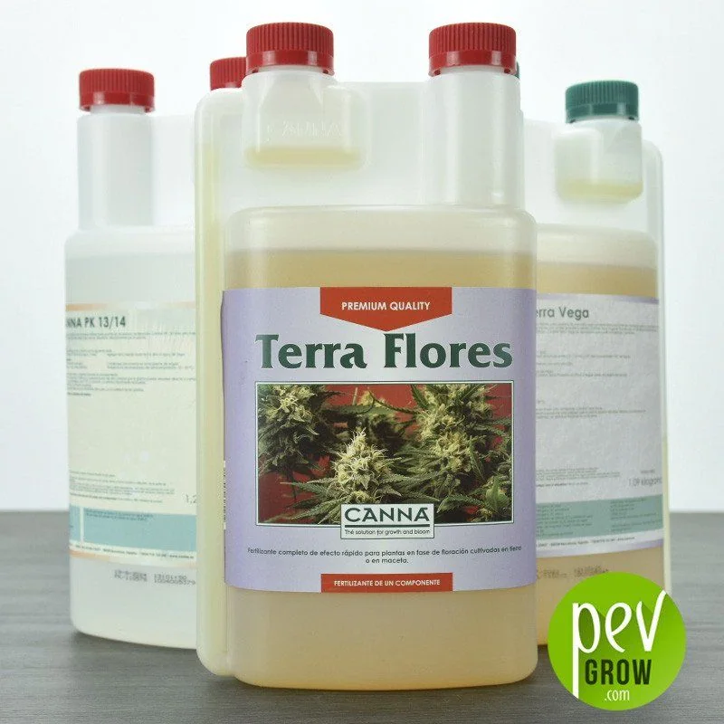 Envase de Canna Terra Flores con tapones rojos y etiqueta con flores de cannabis, delante de otros fertilizantes Canna.