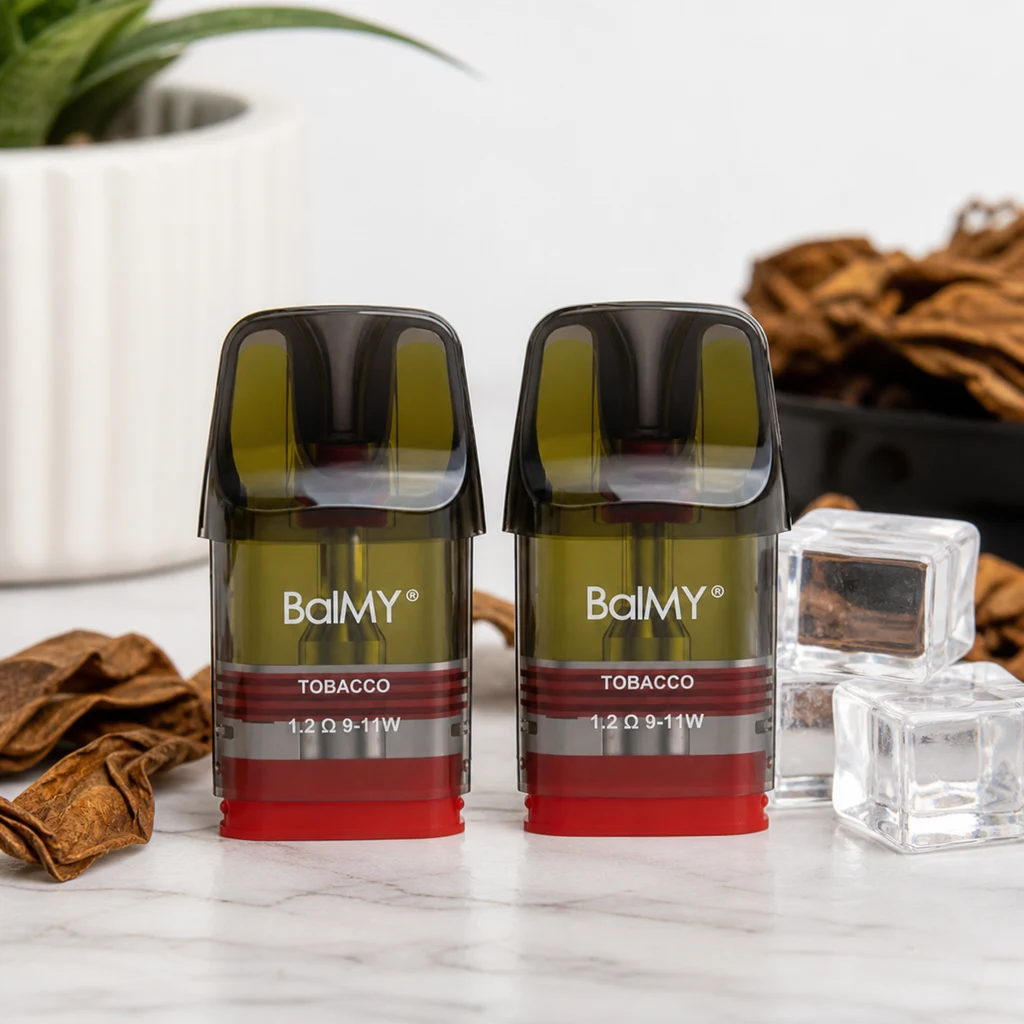 Pods Balmy Tobacco con boquilla oscura, depósito translúcido y base roja; etiquetas de 1,2 Ω y 9–11 W, junto a hojas secas y cubos transparentes.