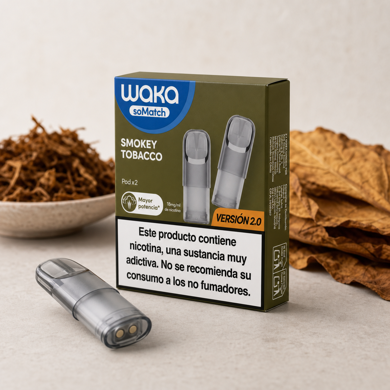 Caja de Waka soMatch Smokey Tobacco con advertencia sobre nicotina y un cartucho delante, junto a tabaco suelto y hojas secas.