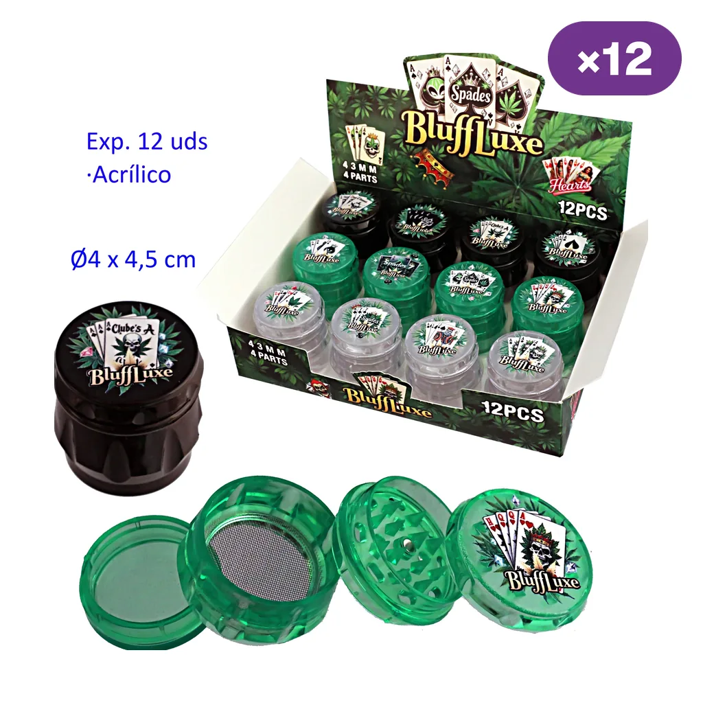 Expositor de grinders BluffLuxe negros, verdes y transparentes, con motivos de cartas; delante, un modelo verde desmontado muestra dientes y malla.