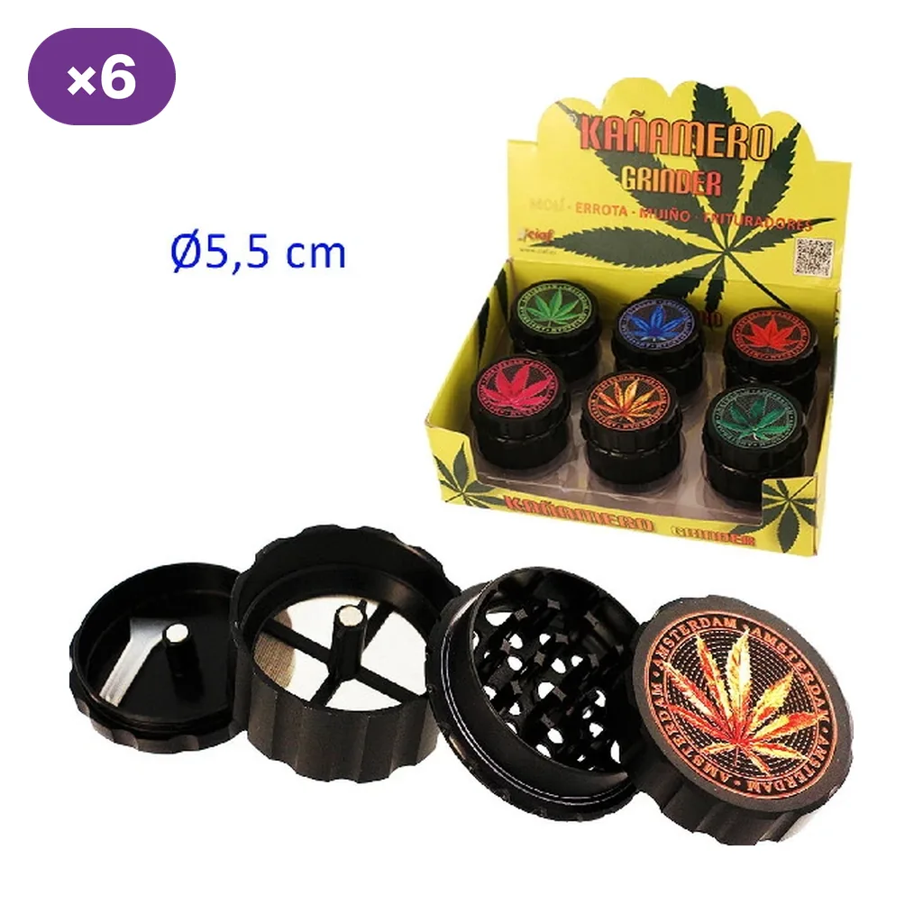 Grinder Kañamero negro de cuatro partes, abierto junto a un expositor con varias unidades decoradas con hojas de cannabis de distintos colores.