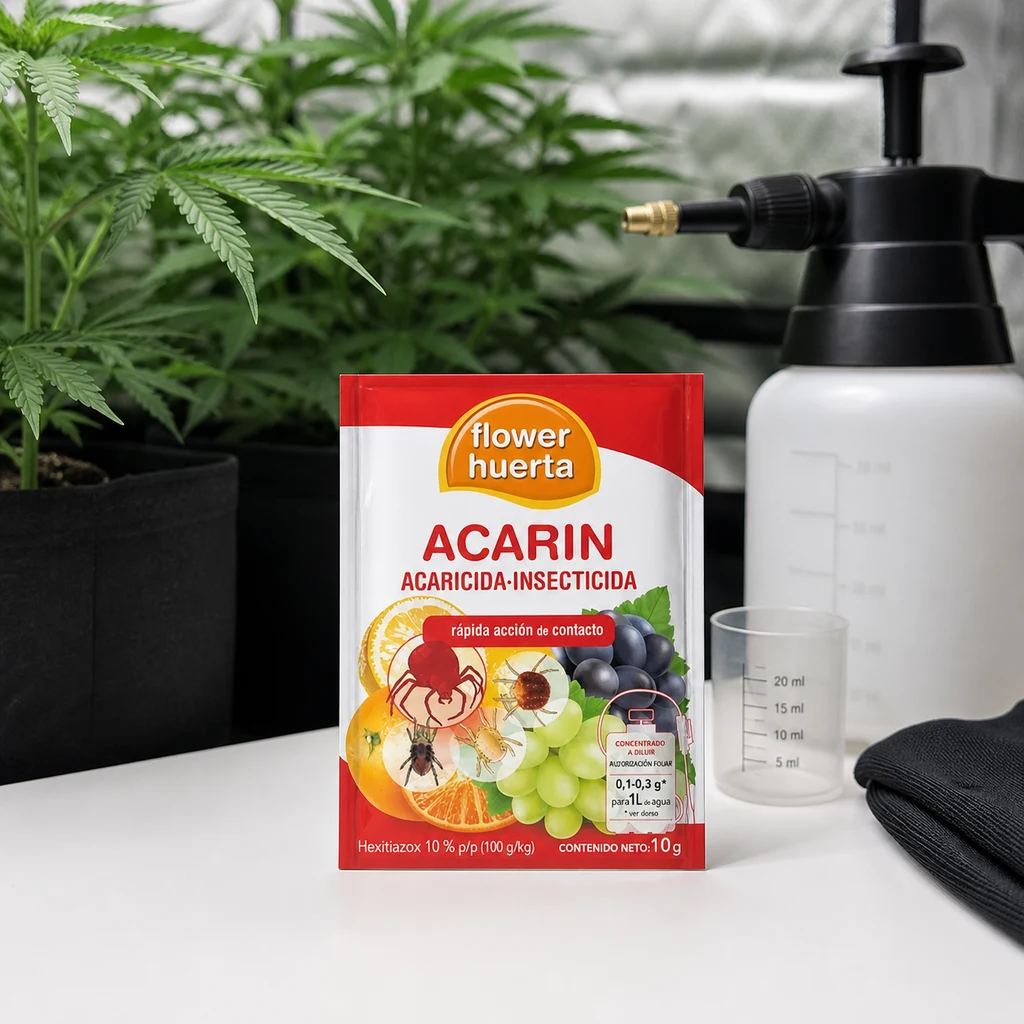 Sobre de Acarin Flower de 10 g sobre una mesa, junto a un pulverizador, un vaso graduado y guantes, con plantas al fondo.