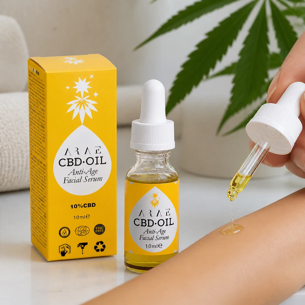 Frasco de aceite de CBD ARAE con caja amarilla y etiqueta de 10 %, junto a una mano que aplica una gota con pipeta sobre el antebrazo. Frasco de aceite de CBD ARAE con caja amarilla y etiqueta de 10 %, junto a una mano que aplica una gota con pipeta sobre el antebrazo.