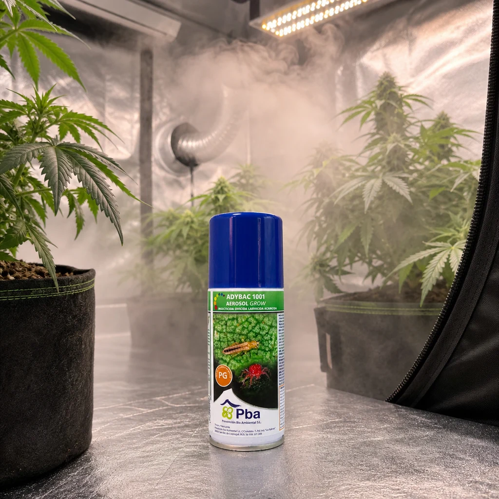 Bote Adybac 1001 Aerosol Grow con tapón azul en primer plano, dentro de un armario de cultivo con plantas y niebla ambiental.