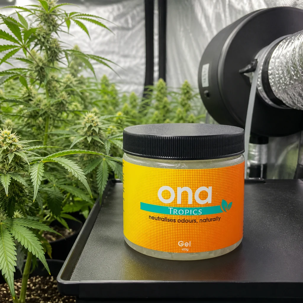 Bote de ONA Gel Tropics con tapa negra y etiqueta naranja sobre una bandeja, junto a plantas de cannabis y un conducto de ventilación.
