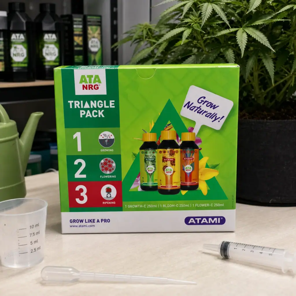 Caja verde del Triangle Pack de Atami sobre una mesa con utensilios de dosificación y una planta al fondo.