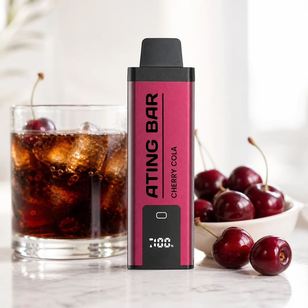 Vaper Ating Cherry Cola de cuerpo rosa y boquilla negra, con pantalla frontal, junto a un vaso de cola con hielo y cerezas.