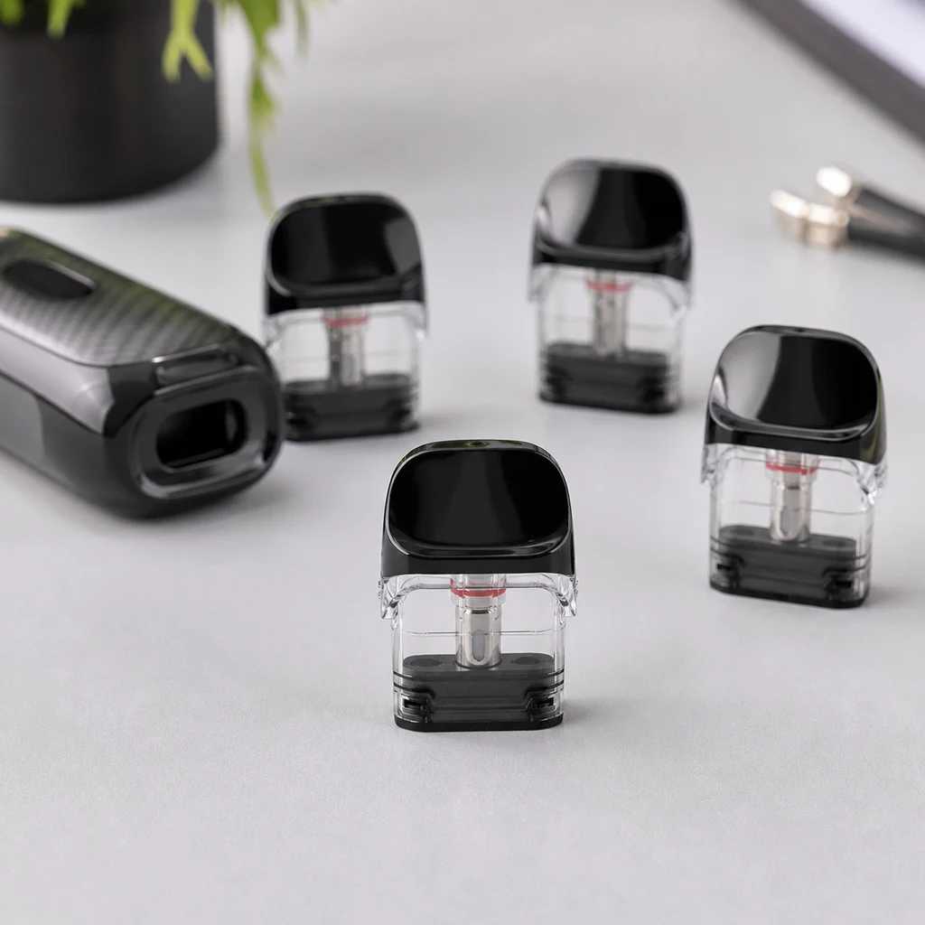 Pods Vaporesso Luxe Q con depósitos transparentes y boquillas negras, dispuestos junto a un dispositivo sobre una mesa gris. Pods Vaporesso Luxe Q con depósitos transparentes y boquillas negras, dispuestos junto a un dispositivo sobre una mesa gris.